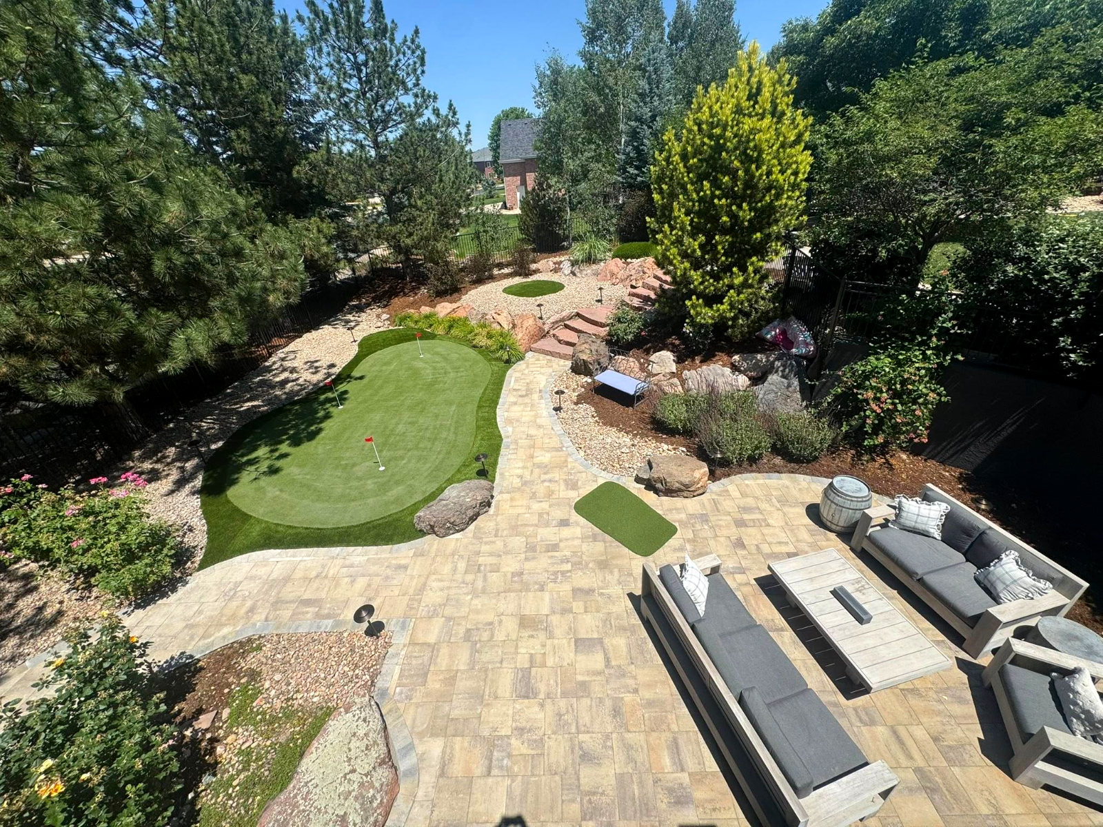 Finished backyard with paver patio, putting green and mature landscaping